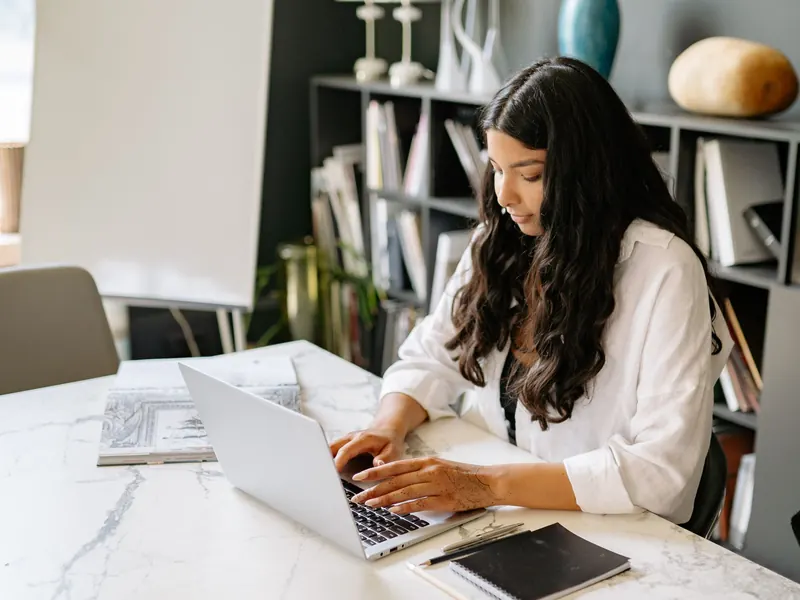 A woman working on a laptop in a bright office